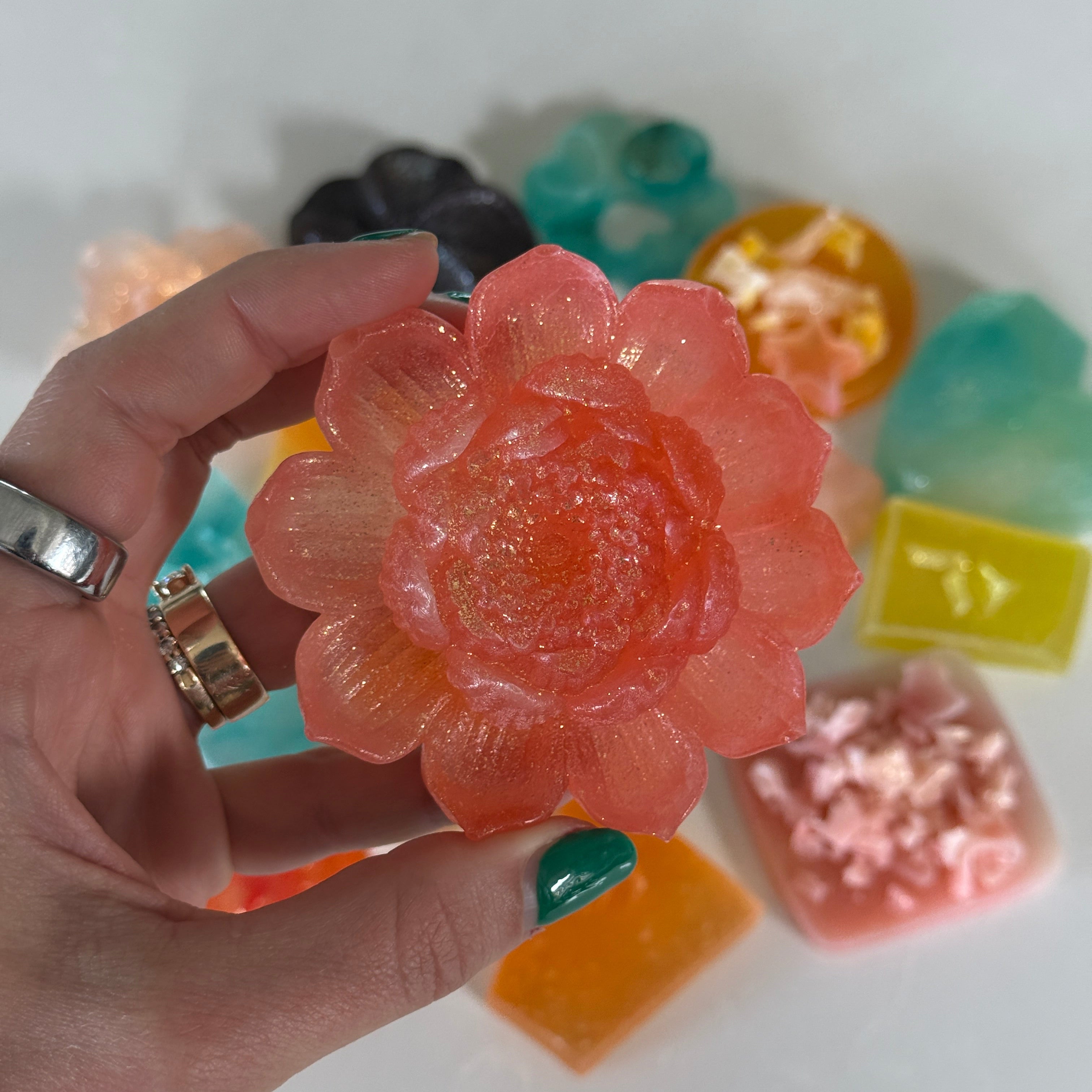 Hand holding a flower-shaped candy with others in the background